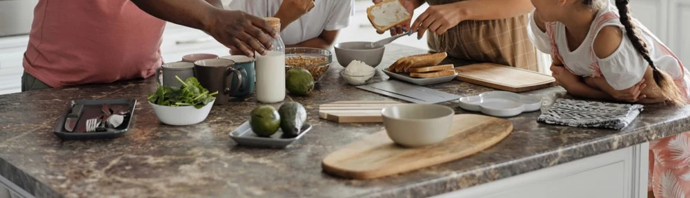 Hands preparing a meal together at a family kitchen counter